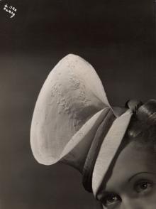Woman modeling a hat by Madame Agnès